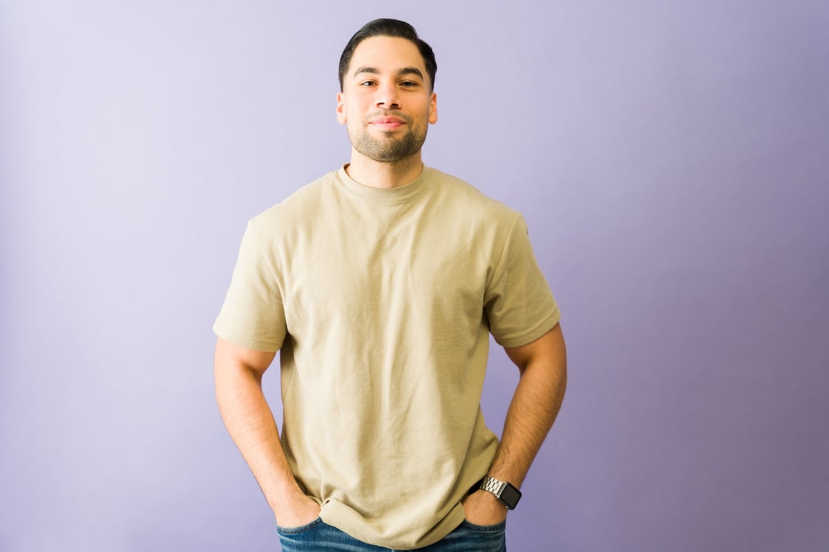 Studio portrait of a young hispanic man standing with hands in pockets, exuding confidence